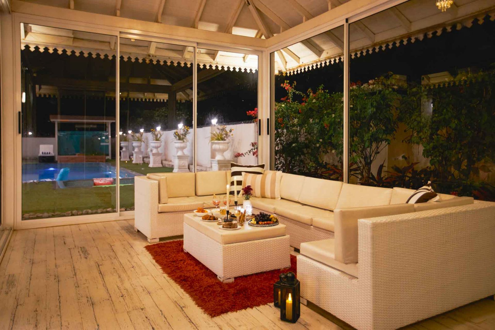 POOLSIDE GAZEBO – Garden gazebo lit at dusk, hills behind, lanterns.